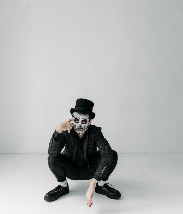 Man performing a controlled bodyweight exercise in a minimalist dark room.