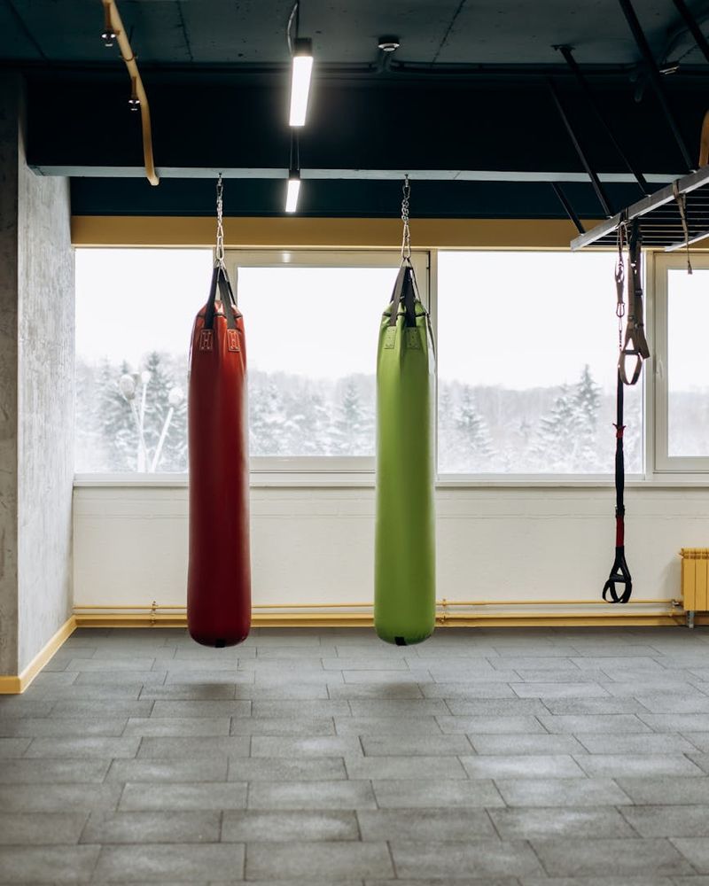 Spacious, well-lit empty room with wooden floors, ready for a workout.